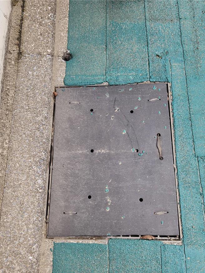 原先有厚重塑胶片覆盖于排水沟孔上，导致排水效率不良。（莺歌区公所提供）