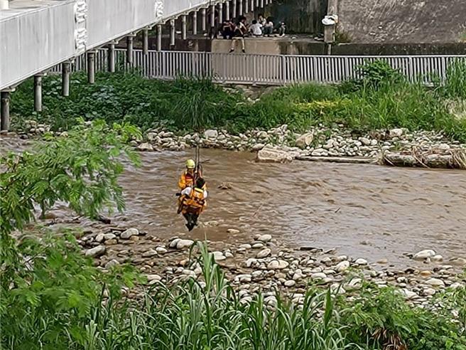 台中市19日午后下起暴雨，旱溪溪水暴涨，北屯区下午4时48分传出31岁男钓客受困旱溪邻近海天桥的河床沙洲。（中市消防局提供／潘虹恩台中传真）