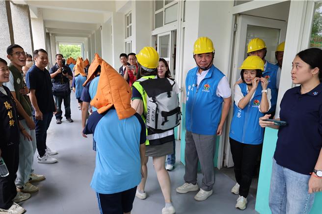 921国家防灾日，苗栗县政府提前一天在竹南镇竹兴国小举办小学生们防灾演练，上午9点21分国家震灾警报响起后，苗栗县长锺东锦陪同小朋友演练避难保护。（谢明俊摄）