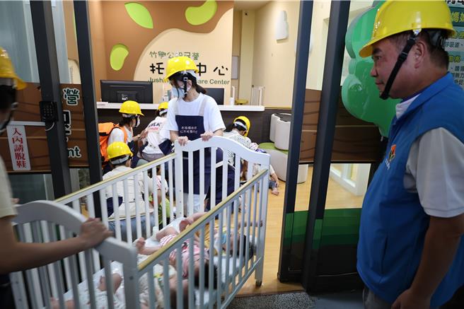 921国家防灾日，苗栗县政府提前一天在竹南镇竹兴国小举办小学生们防灾演练，上午9点21分国家震灾警报响起后，苗栗县长锺东锦陪同小朋友演练避难保护。（谢明俊摄）