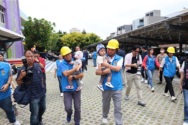 921国家防灾日，苗栗县政府提前一天在竹南镇竹兴国小举办小学生们防灾演练，上午9点21分国家震灾警报响起后，苗栗县长锺东锦保护幼儿避难疏散。（谢明俊摄）