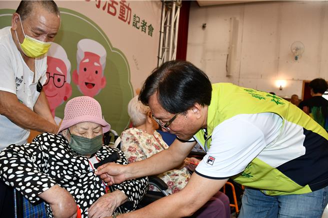 彰化市長林世賢（右）為百歲人瑞吳阿柚（中）戴上金鎖片及致贈紅包。（彰化市公所提供／孫英哲彰化傳真）
