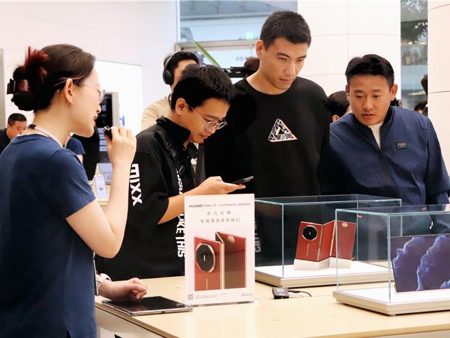 华为三折迭屏手机「Mate XT 非凡大师」今天甫上市即秒杀售罄。图为北京市区一家华为专卖店，店员向消费者介绍新机。（蓝孝威摄）
