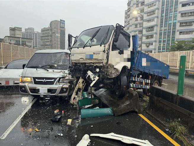 小貨車車頭越過分隔島後，撞到對向車道的另一部車輛。（消防局第三大隊提供）