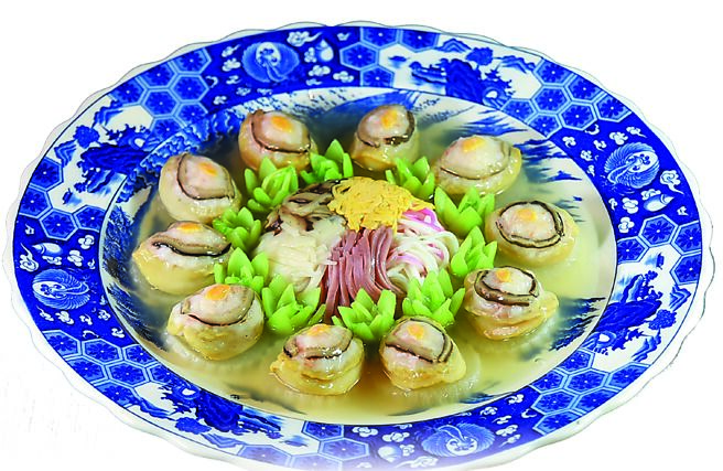 〈五彩白玉鳳眼鮑〉是以白蘿蔔襯底，再逐層鋪上蝦漿、鮑魚後蒸烹，大盤中央是筍絲、火腿絲、香菇絲和蛋絲。圖／姚舜