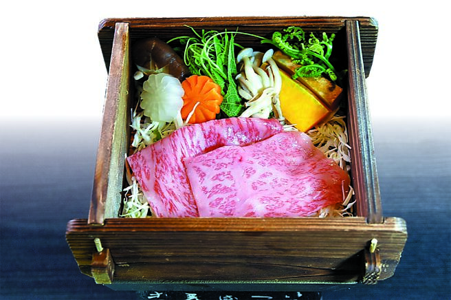 〈A5和牛蒸笼酒蒸〉严选鹿儿岛黑毛A5等级和牛，放入方形杉木蒸笼中与高山高丽菜、金针菇、山苏等时蔬搭配，透过蒸气炊蒸。图／姚舜
