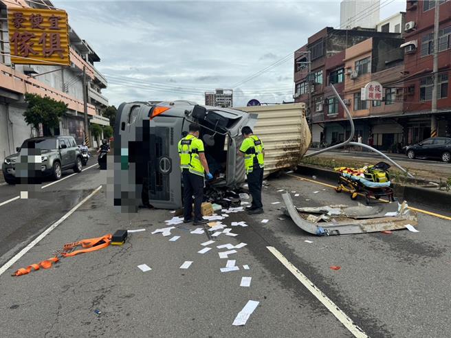 新竹市北區西濱路一段22日上午10點多發生1輛大貨車翻覆事故，撞擊力道過大、車頭扭曲變形，駕駛一度受困車內。（新竹市消防局提供／王惠慧新竹傳真）