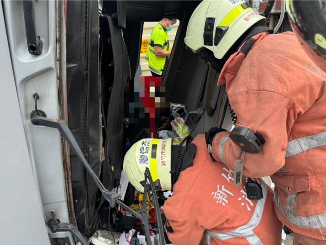 新竹市北區西濱路一段22日上午10點多發生1輛大貨車翻覆事故，撞擊力道過大、車頭扭曲變形，駕駛一度受困車內。（新竹市消防局提供／王惠慧新竹傳真）