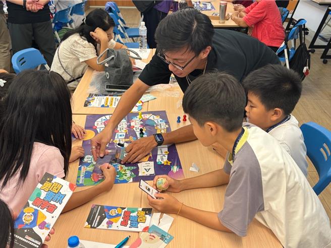新住民及其子女一起游玩移民署制作的锦囊「资讯银河冒险」桌游。（移民署提供）