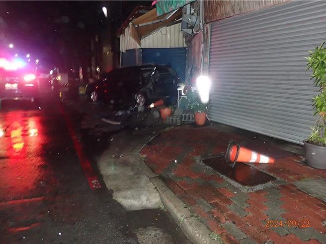黑色轿车被撞衝向路边撞上餐厅铁门及立式招牌。（民眾提供／郭良杰高雄传真）