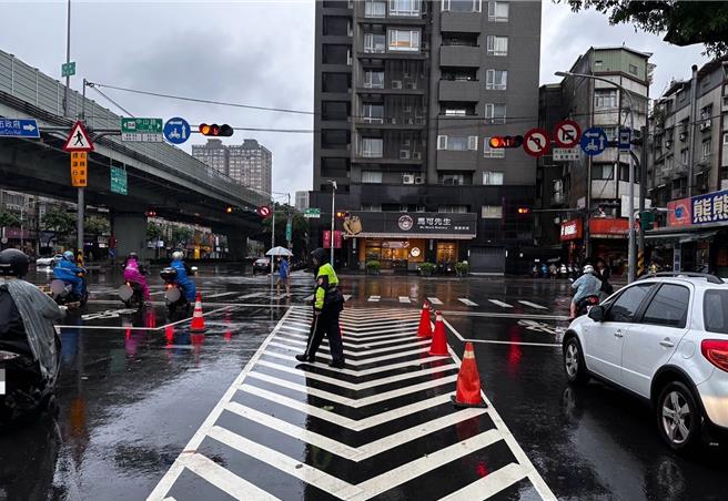 板橋區中山路2段及民生路2段路口因大雨致水溝蓋突出，影響往來人車通行。（海山警分局提供）