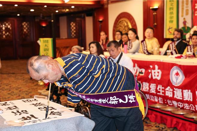 周大观文教基金会永续推动「全球热爱生命运动」，27年来迄今表扬横跨七大洲、79个国家共459位全球热爱生命奖章得主，22日为14位来自世界各地的生命斗士颁奖。现场邀请此届得主郭乙博（见图）现场口衔挥毫书法。（邓博仁摄）