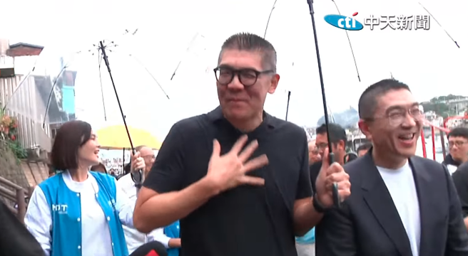 国民党副主席连胜文到基隆力挺市长谢国梁，听到两人共撑一把伞「很浪漫」，连胜文作势呕吐，逗笑全场。（截自中天新闻直播）
