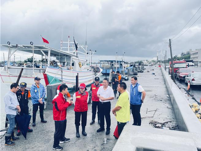 雲林縣長張麗善（左五）22日視察萡子寮漁港的防潮牆（圖右邊緣的水泥構造物），縣府水利處長許宏博（左四）簡報。（周麗蘭攝）
