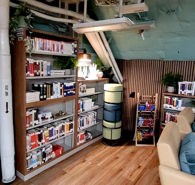 木質地板、綠植與書架，使得林肯號休息區看起來像是公寓的一角。(圖/USO)