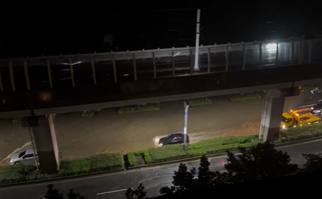 淡水淡金路变成滚滚泥河，3车道遭泥水淹没，多辆车受阻无法通过。（图／翻摄自记者爆料网）