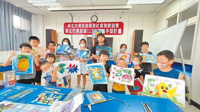 新北市萬里社區繪畫班已開設17年，幫助許多孩子透過課程成功考入美術班。圖為學童與自己的作品合影。（萬里區公所提供／張鎧乙新北傳真）