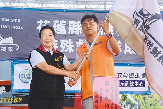 花蓮縣重機械防災協會21日於消防訓練大樓舉辦特殊救援隊成立大會，縣長徐榛蔚（左）授旗給理事長張銘偉（右），感謝業界自主凝聚防災共識，守護花蓮安全。（王志偉攝）