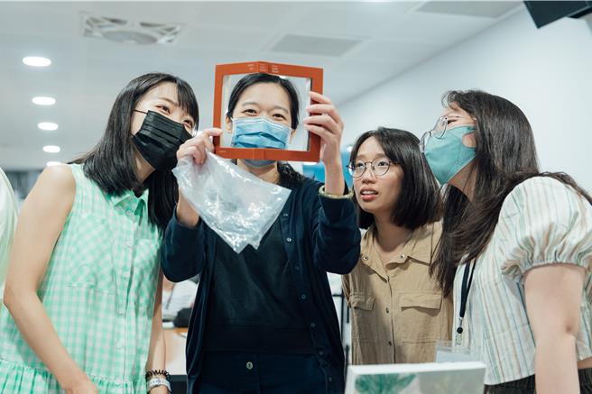 导师周彦彤（左二）带着学员们观赏客座讲师吴睿哲带来的特殊造型的艺术书。（画面翻摄／纪爰高雄传真）