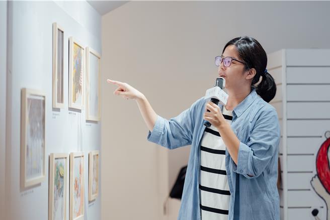 学员陈庭安向来参与展览开幕分享会的读者介绍自己的创作作品。（画面翻摄／纪爰高雄传真）