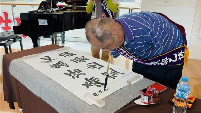中國大陸無臂書法達人郭以博現場表演用腳寫書法。（吳佩蓉攝）