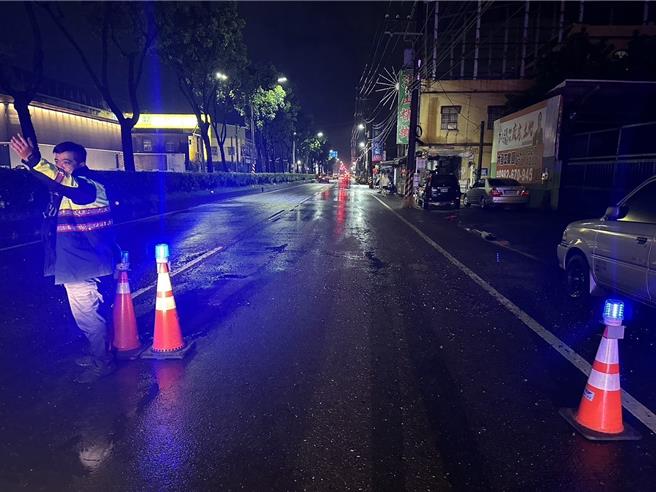 高雄市大寮區鳳林二路因連日豪大雨沖刷造成路面出現坑洞，造成5部車撞損及2名騎士受傷，警方派員到場設立警告標誌。（民眾提供／郭良傑高雄傳真）