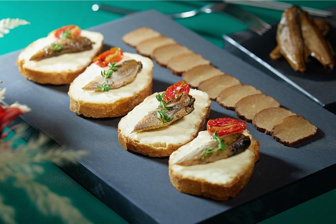 「秋田油渍叉牙鱼普切塔」是以秋田县特产的油渍叉牙鱼与独特的熏制萝卜为主，搭配奶油乳酪，是日本酒的最佳搭檔，售价480元加1成。(JR东日本大饭店台北提供)