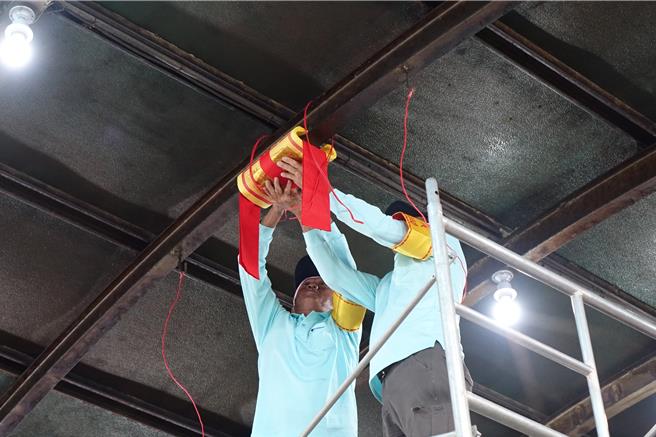 专人将太极金及五谷包等，绑在中梁上，两侧挂上粽子。（罗琦文摄）