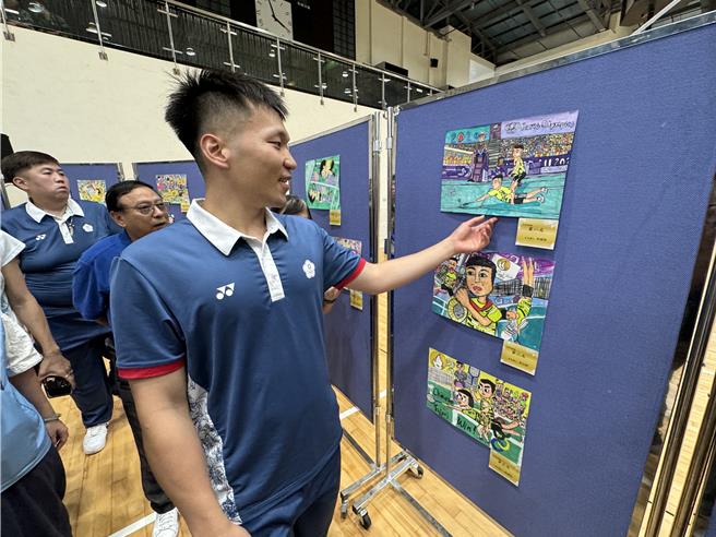 李洋看著教育處先前舉辦的「慶祝2024巴黎奧運李洋奪冠繪畫比賽」得獎作品，滿心歡喜。（于家麒攝）