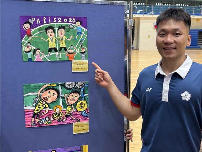 李洋看著教育處先前舉辦的「慶祝2024巴黎奧運李洋奪冠繪畫比賽」得獎作品，滿心歡喜。（于家麒攝）