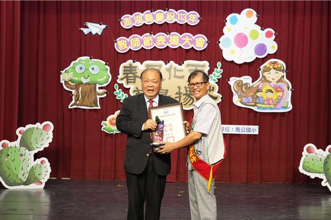 澎湖縣政府為表彰教師傑出貢獻與努力，25日上午在馬公國小內的特殊教育資源中心舉行「澎湖縣慶祝113年教師節表揚大會-春風化雨 菊島揚芬」。圖為縣長陳光復（左）表揚服務滿40年資深優良教師花嶼國小黃國揚（右）。（澎湖縣政府提供／許逸民澎湖傳真）