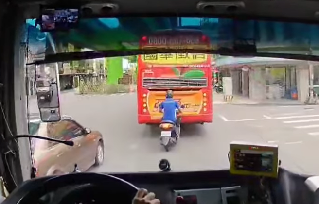 日前有辆机车于车道上乱遭，差点遭游览车与公车夹爆成「夹心饼乾」。（图／翻摄自脸书八卦村 - 行车纪录器影片上传中心）
