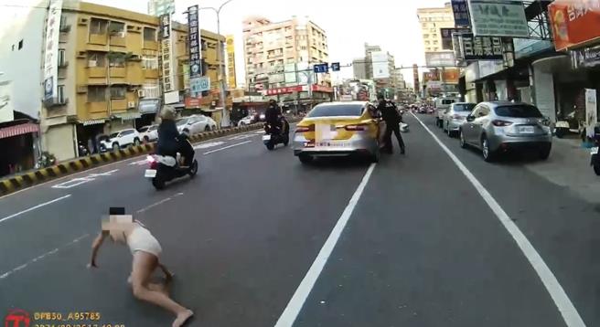 侯女跳车后，坐在台南永康区中华路车道上，吓坏用路人。（读者提供／曹婷婷台南传真）