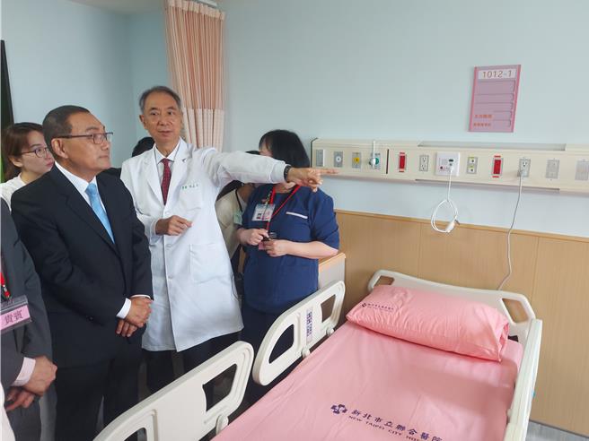 新北市長侯友宜（左一）27日在市立聯醫院長項正川（左二）等人陪同下，參觀負壓隔離病房。（張鎧乙攝）