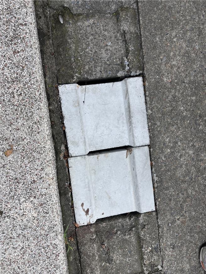 桃园市平镇区上海路与中庸路交界1处户外停车场廊道，因水沟盖破损，造成5岁男童经过该处时，不慎跌入造成左小腿大面积挫伤。（廖姮玥摄）