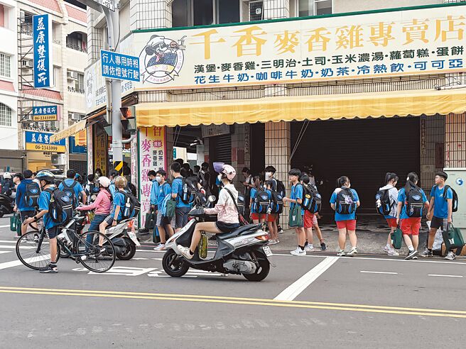 由于没有人行道加上骑楼不够畅通，学生放学走在马路上的画面，让不少家长看了捏一把冷汗。（曹婷婷摄）