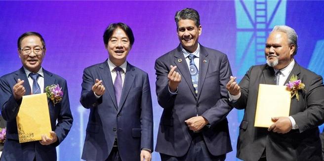 总统赖清德（左二）与帛琉总统惠恕仁（右二）共同见证世界台湾商会联合总会会长李天柒（左一）与帛琉共和国驻台大使欧儒侃（右一）签署「关于促进帛琉观光发展及投资联合声明」。图／外交部提供