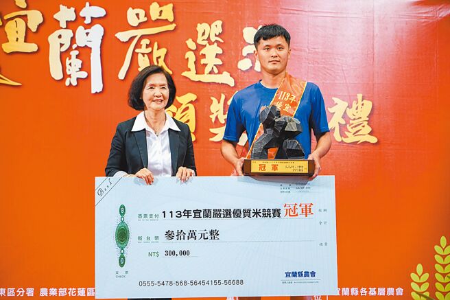 宜蘭嚴選優質米競賽27日公布結果，冬山鄉28歲青農劉耀群（右）奪得冠軍，縣長林姿妙（左）頒發獎座與30萬元獎金。（李忠一攝）