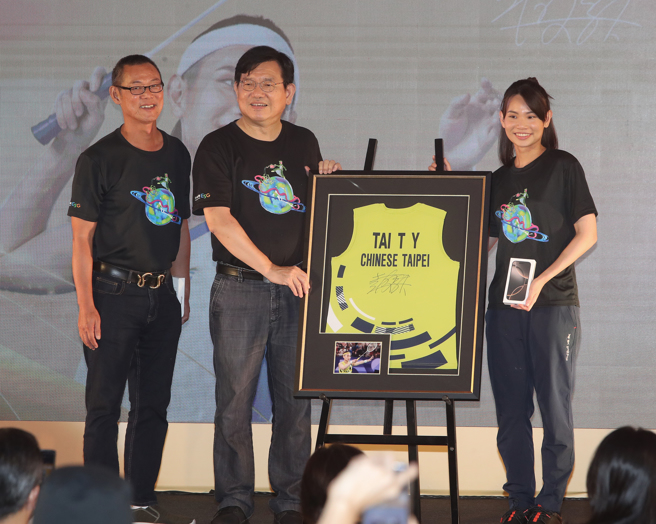 戴资颖（右）出席中华电信「拥『戴』精彩 继往开来」粉丝见面会，致赠巴黎奥运比赛球衣给中华电信执副林荣赐（中），「戴爸」戴楠凯（左）也上台共享荣耀。（刘宗龙摄）