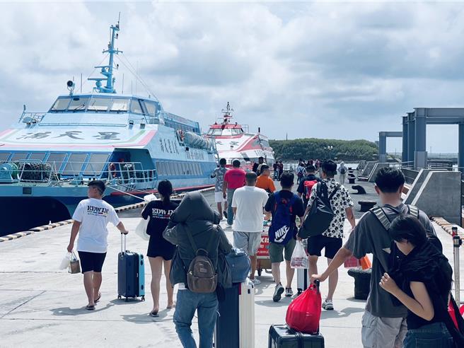 山陀儿颱风步步进逼，在澎湖游客担心被「关岛」滞留，旅游淡季的马公港29日现「逃难潮」，旅客赶着搭船返台。（许逸民摄）