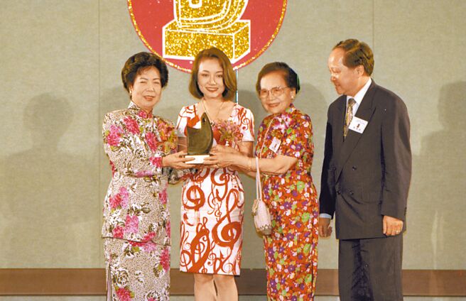 吴冠英（左二）当年从总统夫人曾文惠（左）手中领到「十大杰出女青年奖」，右起为她的哥哥吴建国、吴妈妈。（资料照片）