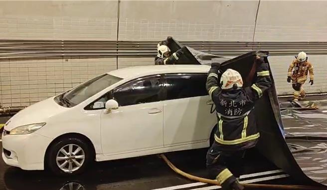 演練模擬1輛電動車於隧道內冒出大量濃煙，消防隊員到場，使用滅火毯覆蓋。（新北市消防局提供）