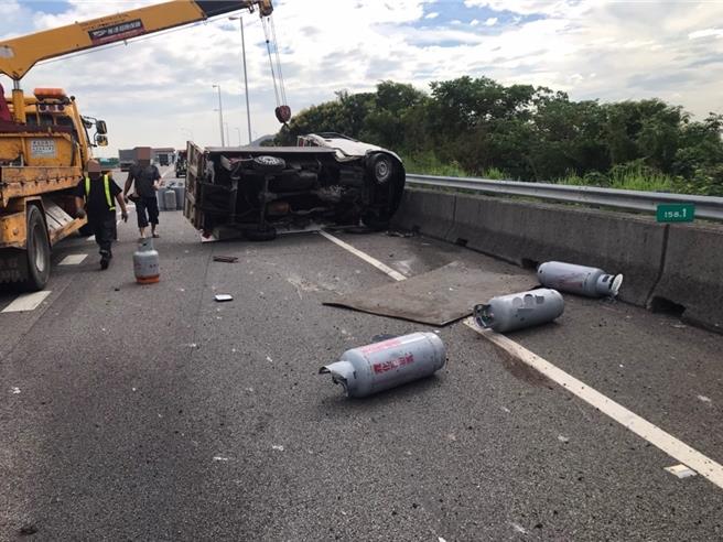 小货车失控撞击外侧护栏后，因撞击力道过大瞬间翻覆，车后斗载送的瓦斯桶散落一地。（国道警方提供／张妍溱台中传真）