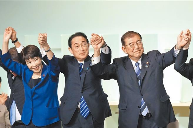 石破茂（右）9月27日当选自民党总裁，日本首相岸田文雄（中）与高市早苗（左）等眾候选人高举双手庆祝。（美联社）