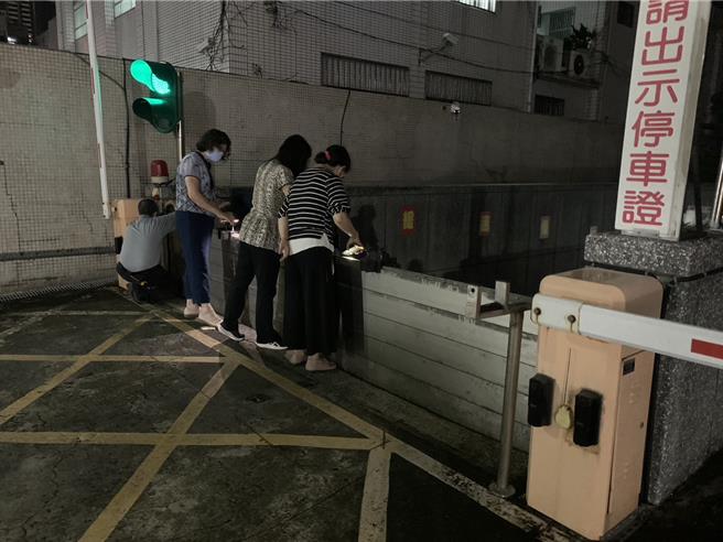 辦公大樓忙著在停車場入口架起擋水板和堆沙包來擋水。（郭良傑攝）