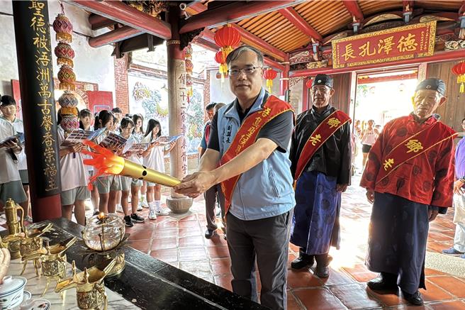 金門縣副縣長李文良(前)率縣府團隊向牧馬侯陳淵祝禱後，請引聖火並傳交給大會聖火隊。(于家麒攝)