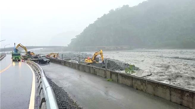 金峰乡嘉兰村河堤水位高涨，重机具吊挂消波块防堵溢堤。（萧嘉蕙摄）
