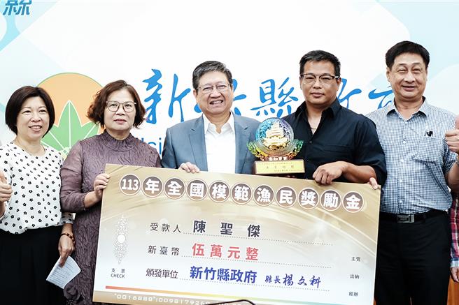 竹北市民陈圣杰（右二），接手父亲的传统渔业，以科技业管理方式提升渔获量，获选今年「全国模范渔民」，县长杨文科（中）1日颁发5万元奖金表扬。（罗浚滨摄）
