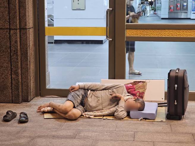 阿国纸箱铺地躺睡、家当摆在一旁。（记者游定刚拍摄）