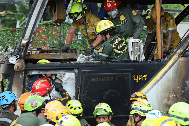 2024年10月1日，泰國消防隊員從一輛載有學校師生，起火燃燒的巴士上轉移罹難者。（路透社）